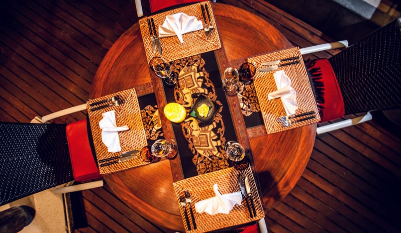 Teak Elephant Top-down view of a luxury Thai-inspired restaurant table setting for four people at Shandrani for 2 by Kenwood Travel
