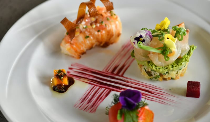 Le Sirius Artistic avant-garde seafood plating showcasing meticulous food design, edible flowers, and geometric sauce accents on a minimalist background at Shandrani for 2 by Kenwood Travel