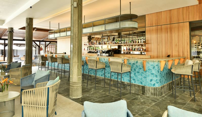 Blue Bay Bar Luxury hotel bar and lounge area with contemporary seating, fully stocked bar, and open-air tropical resort ambiance at Shandrani for 2 by Kenwood Travel