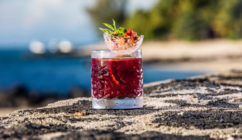 The Wild Bar Refreshing tropical red cocktail garnished with fresh fruit salsa on a sunny beach at a luxury resort at Shandrani for 2 by Kenwood Travel