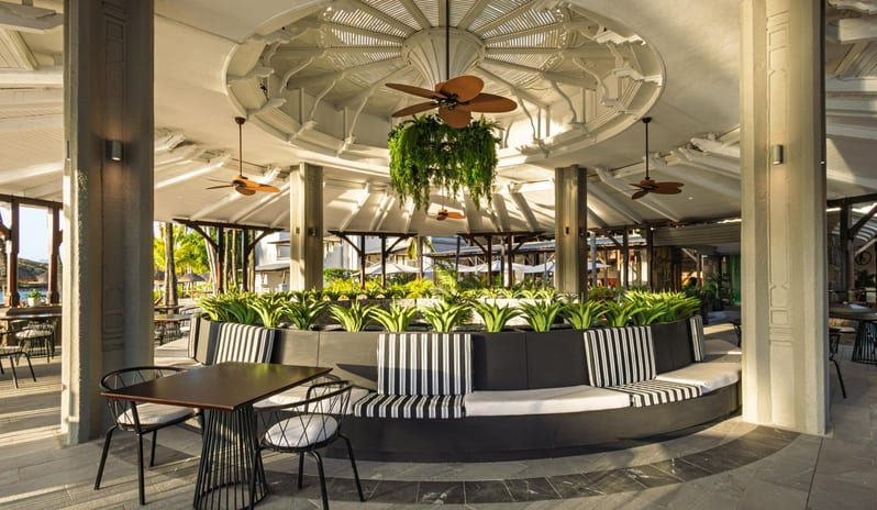 Le Boucanier Custom black and white striped circular booth seating surrounded by indoor plants in a contemporary pavilion restaurant at Shandrani for 2 by Kenwood Travel