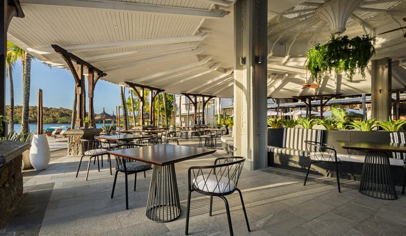 Le Boucanier Custom black and white striped circular booth seating surrounded by indoor plants in a contemporary pavilion restaurant at Shandrani for 2 by Kenwood Travel