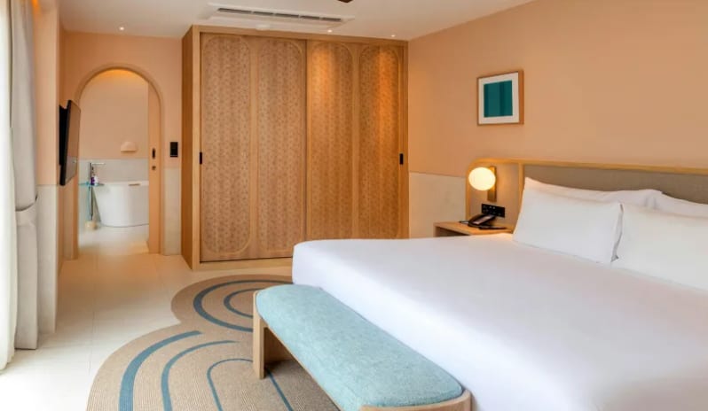 One Bedroom Private Villa Modern one-bedroom private villa luxury bedroom with King bed, light wood closets, and view into an ensuite bathroom with bathtub at Centara Karon Villas Phuket by Kenwood Travel