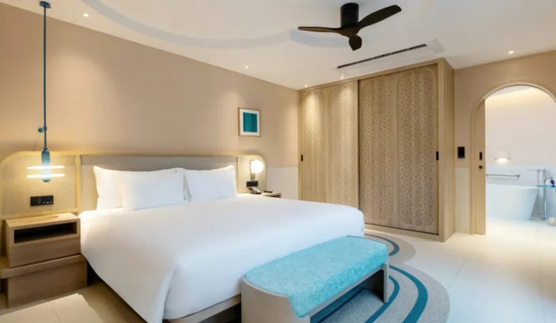 One Bedroom Pool Villa Japandi style bedroom interior featuring a light wood sliding wardrobe, arched doorway, and turquoise accents at Centara Karon Villas Phuket by Kenwood Travel