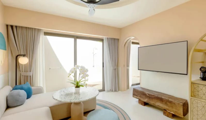 One Bedroom Private Villa kingmodern sofa, marble coffee table with white orchids, large wall-mounted TV, and sliding glass doors leading to a private outdoor space at Centara Karon Villas Phuket by Kenwood Travel