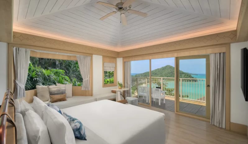 Villa Ocean View Luxury villa bedroom with a white king bed, large glass doors opening to a balcony with a panoramic ocean and island view at Centara Villas Phi Phi Island by Kenwood Travel
