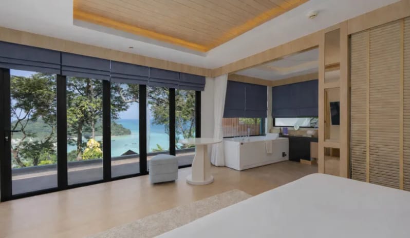 Duplex Suite Spa Ocean View Hotel duplex suite bedroom looking out to a scenic ocean view with large glass doors and private tub at Centara Villas Phi Phi Island by Kenwood Travel
