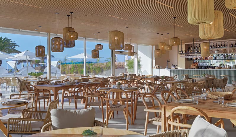 Kanna Beach Club interior design with sustainable wood ceiling, woven light fixtures, and outdoor patio seating near the beach at Paradisus Gran Canaria by Kenwood Travel