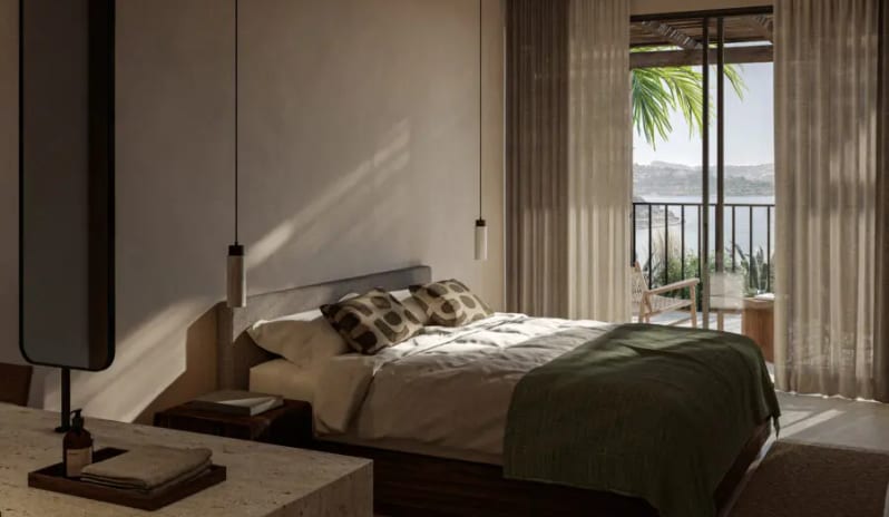 Classic luxury minimalist hotel room at OKU Ibiza featuring earth tones, a balcony with palm tree views, and modern pendant lighting at OKU Bodrum by Kenwood Travel