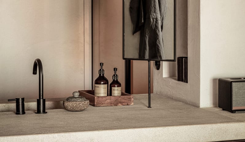 Classic Room with Shared Pool Minimalist bathroom vanity featuring a light stone countertop, matte black faucet, and Meraki apothecary bottles in a wooden tray at OKU Bodrum by Kenwood Travel