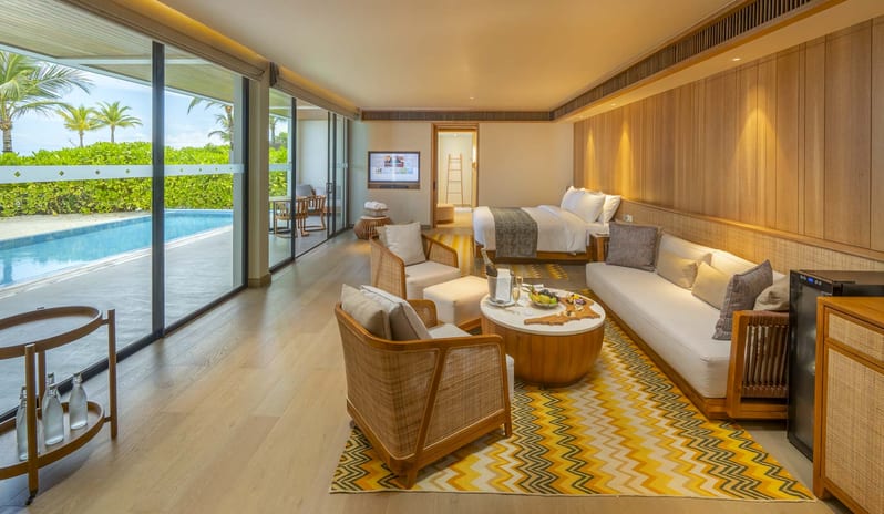 Two Bedroom Beach Residence with Private Pool Modern luxury beachfront villa suite featuring a private lap pool, outdoor patio, chic wooden interiors, and a lounge area with ocean views at Kuda Villingili Resort Maldives by Kenwood Travel
