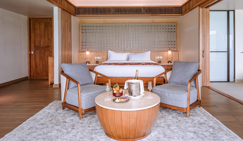 Sunrise Water Villa with Private Pool bedroom suite with private pool access, featuring modern tropical decor, champagne service, and elegant wooden accents at Kuda Villingili Resort Maldives by Kenwood Travel