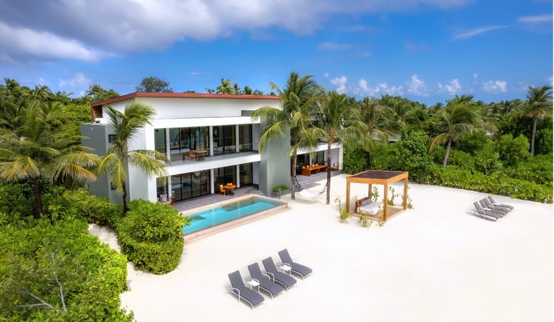 Two Bedroom Beach Residence with Private Pool private swimming pool, sun loungers, a beach cabana, and a hammock nestled among tropical palm trees at Kuda Villingili Resort Maldives by Kenwood Travel