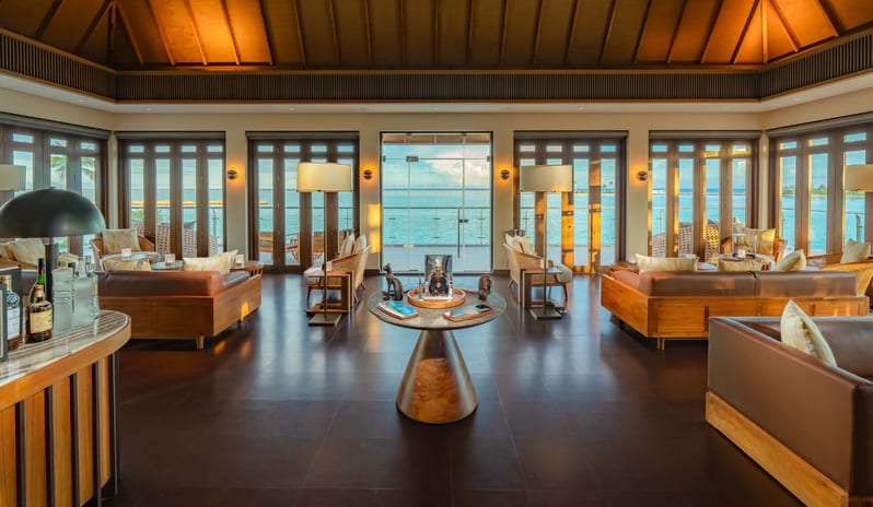 Cigar Lounge The lounge has comfortable couches, a central table with decorations, and a small bar. It has a relaxed and inviting atmosphere at Kuda Villingili Resort Maldives by Kenwood Travel