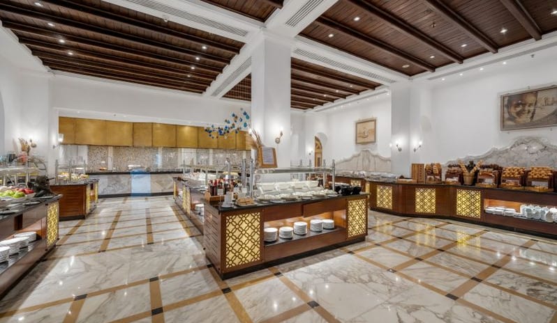 Tirana A grand all-inclusive resort breakfast buffet station arranged in a bright dining hall with a detailed wooden tray ceiling at Royal Savoy Sharm El Sheikh by Kenwood Travel