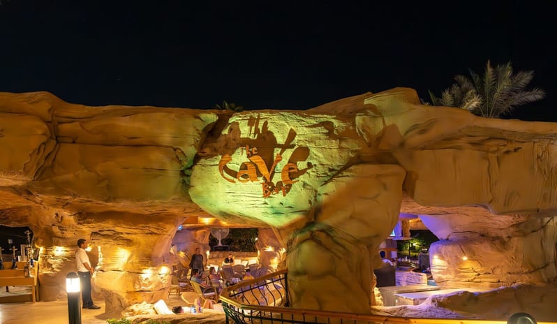 Cave Bar Exterior view of The Cave Bar entrance carved into rock with warm night lighting at Royal Savoy Sharm El Sheikh by Kenwood Travel