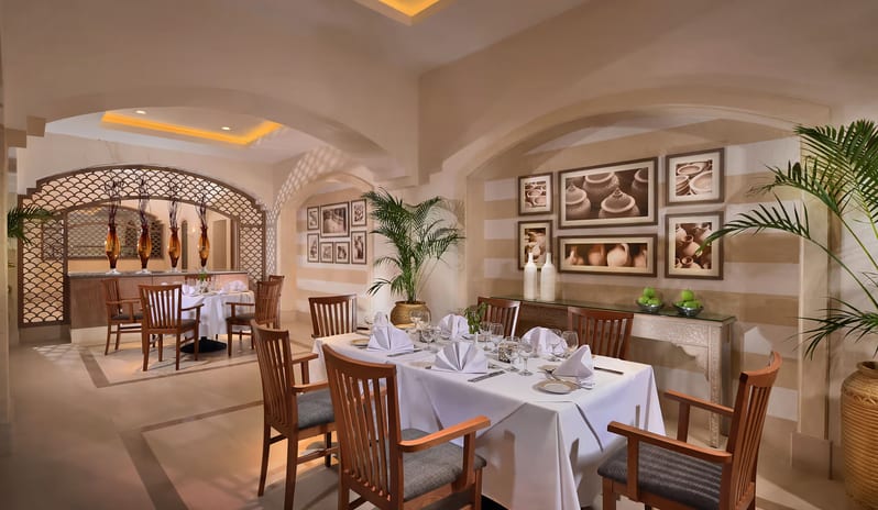 Zohreya Restaurant arched doorways, framed wall art, and fine dining setups at Steigenberger Alcazar by Kenwood Travel