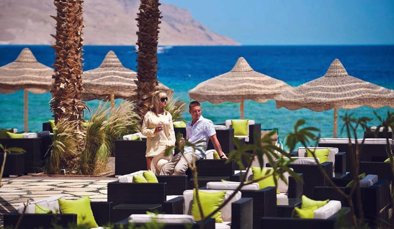 Palm Beach Bar Couples seating area at Palm Beach Bar & Lounge overlooking the tropical beach resort coast at Baron Resort Sharm El Sheikh by Kenwood Travel