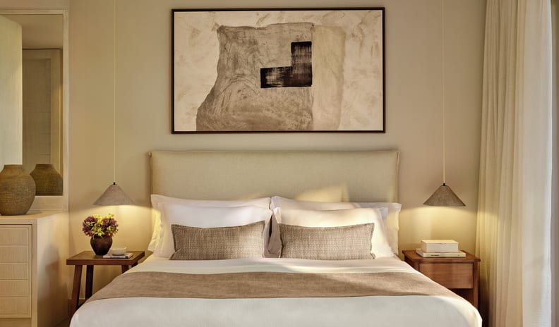 Deluxe Double Room Private Garden Sea View large bed with neutral linens and accent pillows, flanked by wooden nightstands and hanging cone pendant lights at Sani Club by Kenwood Travel