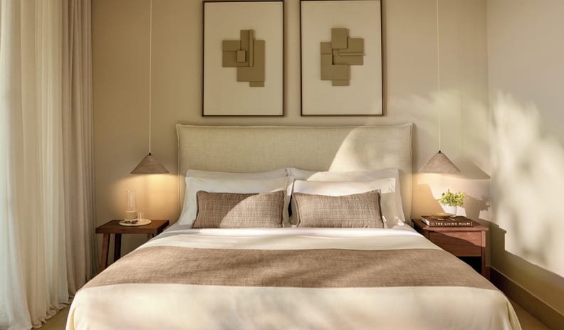 Junior Suite Grand Balcony Sea View bedroom wall decor with a pair of abstract geometric framed art pieces hung symmetrically above a king-size bed with conical hanging pendant lamps at Sani Club by Kenwood Travel