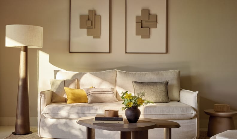 One Bedroom Bungalow Suite Private Garden Pool Front Warm beige resort lounge area with a comfortable cream sofa under soft sunlight, decorated with a textured jute rug and contemporary wooden furniture at Sani Club by Kenwood Travel