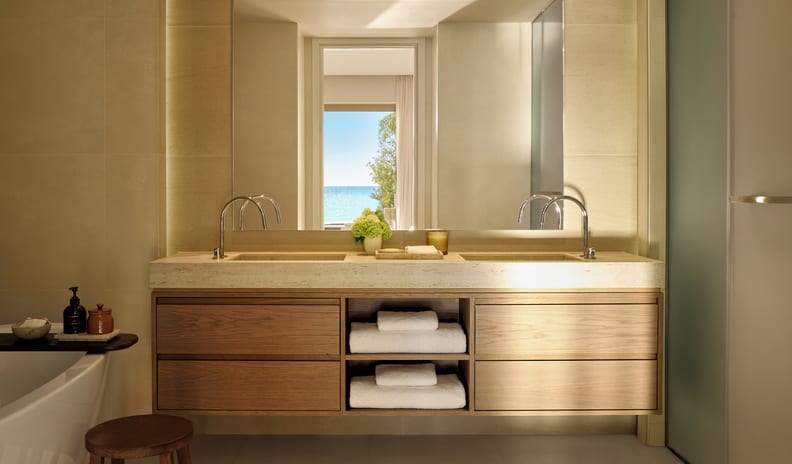 One Bedroom Bungalow Suite Private Pool Sea View Modern bathroom interior with a floating oak wood vanity, natural stone countertop, integrated sinks, and minimalist chrome faucets at Sani Club by Kenwood Travel