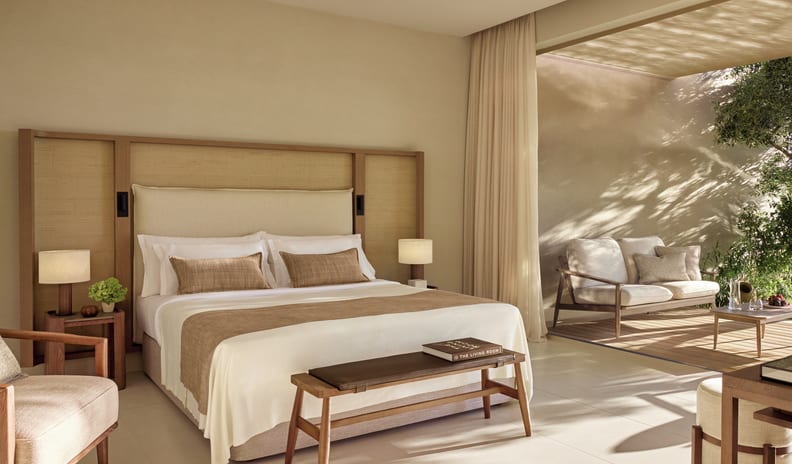 Two Bedroom Bungalow Suite PrIvate Pool Beach Front Elegant resort bedroom opening onto a sunlit outdoor lounge area with wooden furniture at Sani Club by Kenwood Travel