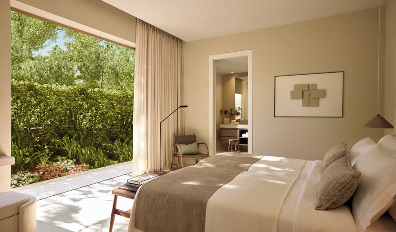 Two Bedroom Bungalow Suite PrIvate Pool Beach Front Modern minimalist bedroom in neutral tones featuring earth-colored linens and direct access to a lush green outdoor terrace at Sani Club by Kenwood Travel
