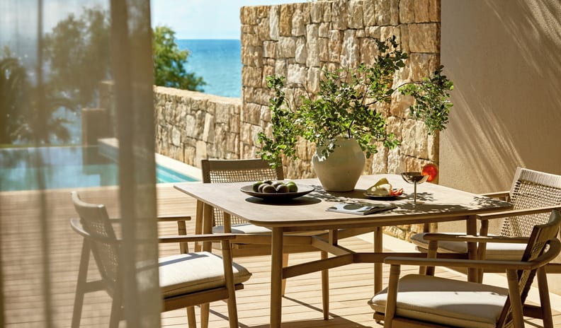One Bedroom Bungalow Suite Private Pool Sea View Private resort villa patio with a wooden dining table, set next to a swimming pool with stone walls and a sea view at Sani Club by Kenwood Travel