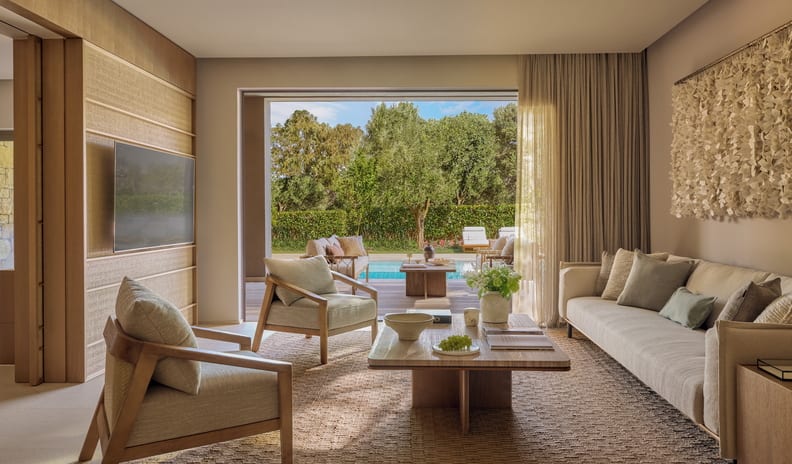 Three Bedroom Grand Residence Private Pool Garden View Bright and spacious villa lounge room with upscale seating, opening directly out to a sunlit private swimming pool and garden patio at Sani Asterias by Kenwood Travel
