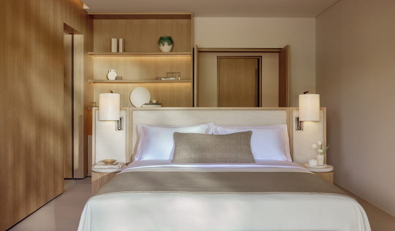 Three Bedroom Grand Residence Private Pool Garden View Elegant villa master bedroom showcasing a king bed with neutral linen layers, soft ambient lighting, and sophisticated custom woodwork design at Sani Asterias by Kenwood Travel