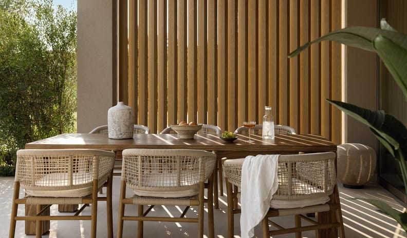Three Bedroom Villa Pr. Pool Garden View dining area of a luxury hotel villa, showcasing elegant neutral-toned outdoor furniture, shaded by architectural wooden louvers with a view of tropical greenery at Sani Asterias by Kenwood Travel