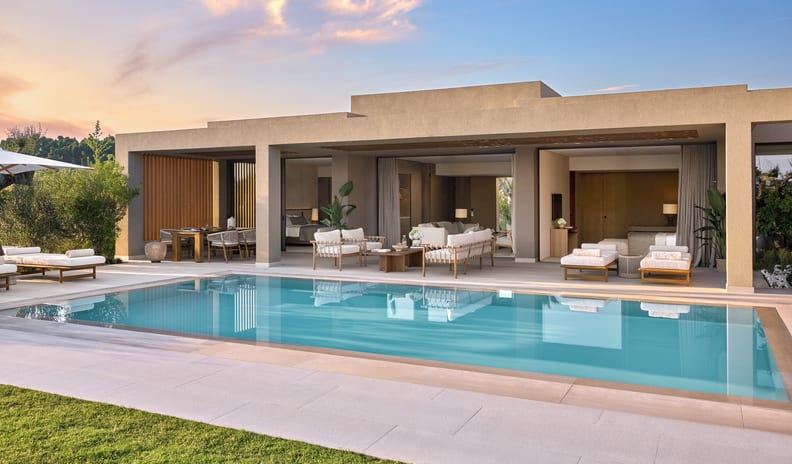 Three Bedroom Villa Pr. Pool Marina View luxury resort villa exterior with a large private swimming pool, sun loungers, and an open-concept living area with patio seating, captured during a vivid sunset sky at Sani Asterias  by Kenwood Travel