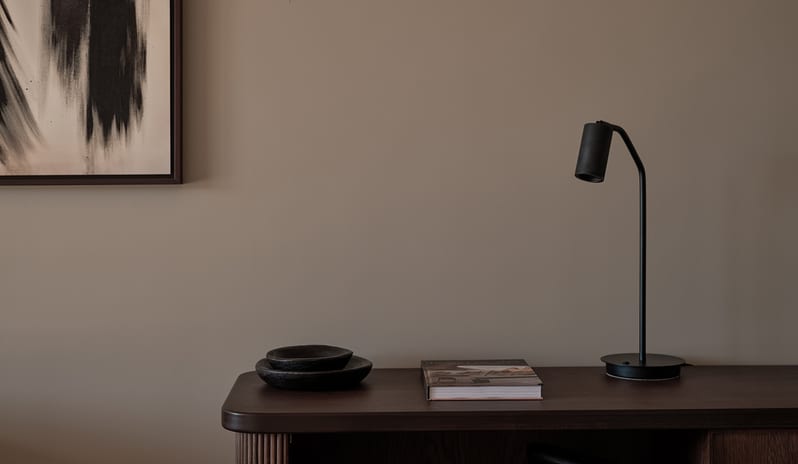Two Bedroom Suite with Private Pool dark wood desk with fluted detailing, a matte black desk lamp, a mid-century woven accent chair, and abstract black brushstroke art at OKU Bodrum by Kenwood Travel
