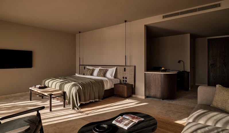 Deluxe Suite with Private Pool room interior with a king bed, integrated living area, and elegant dark wood accents at OKU Bodrum by Kenwood Travel