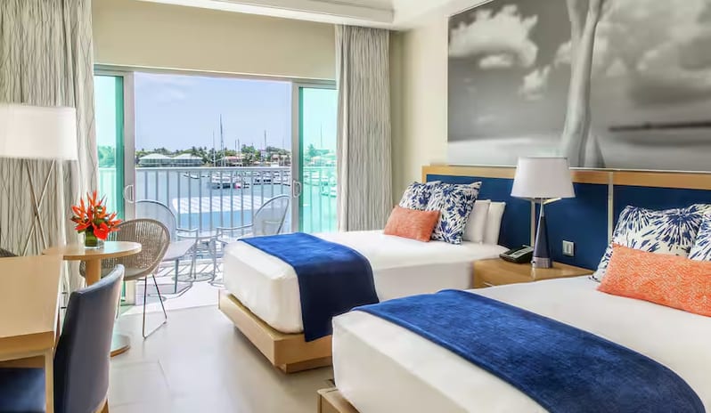 Marina View Terrace Doubles luxury hotel room with two beds, private balcony terrace, and marina view at Harbor Club St. Lucia, Curio Collection by Hilton by Kenwood Travel
