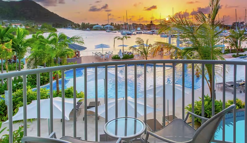 Marina View Terrace Doubles Resort balcony terrace view of a swimming pool and marina at sunset at Harbor Club St. Lucia, Curio Collection by Hilton by Kenwood Travel