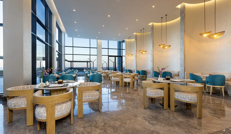 Executive Lounge Luxury resort executive lounge interior showing modern wooden and teal seating, marble floors, and panoramic windows at Rixos Radamis Sharm El Sheikh by Kenwood Travel