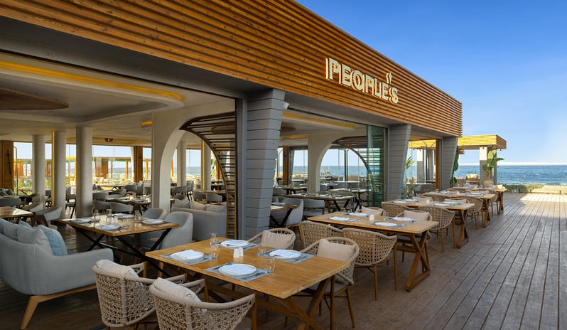 People's Restaurant Outdoor beachfront terrace dining tables and wooden deck seating at Rixos Radamis Sharm El Sheikh by Kenwood Travel