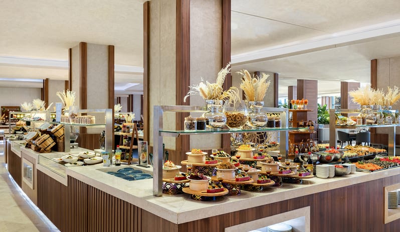 Veranda array of gourmet dishes, fresh salads, desserts, and elegant decorative glass vases with dried pampas grass at Rixos Radamis Sharm El Sheikh by Kenwood Travel