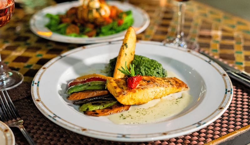 Rosmarino beautifully plated fine dining seafood dinner paired with rosé wine at a luxury resort restaurant table at Savoy Sharm El Sheikh by Kenwood Travel