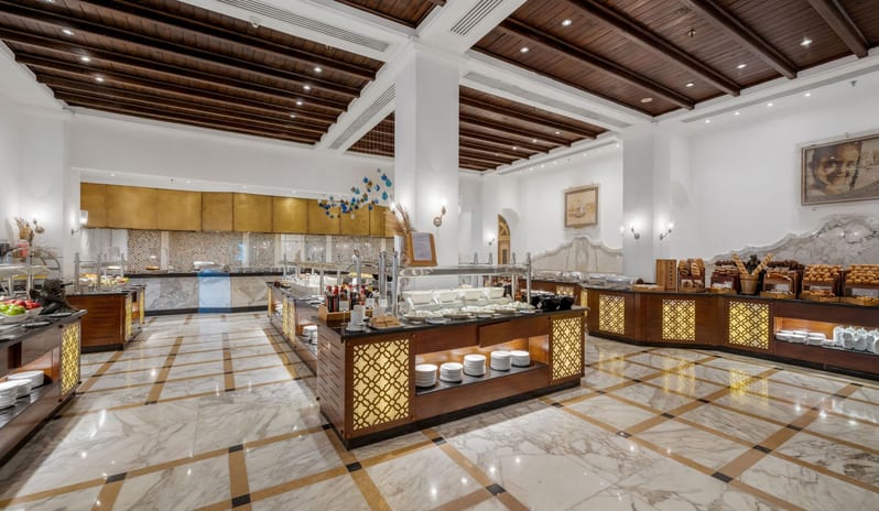 Tirana spacious luxury hotel buffet dining room with a wide selection of food counters, marble tiled floors, and a dark wood paneled ceiling at Savoy Sharm El Sheikh by Kenwood Travel