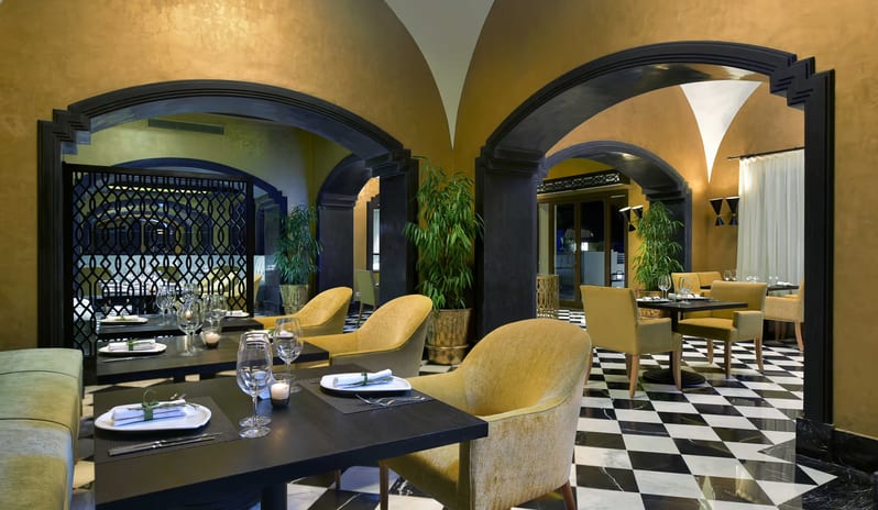 La Maison golden arched ceilings, checkerboard floors, and plush yellow armchairs at Steigenberger Alcazar by Kenwood Travel