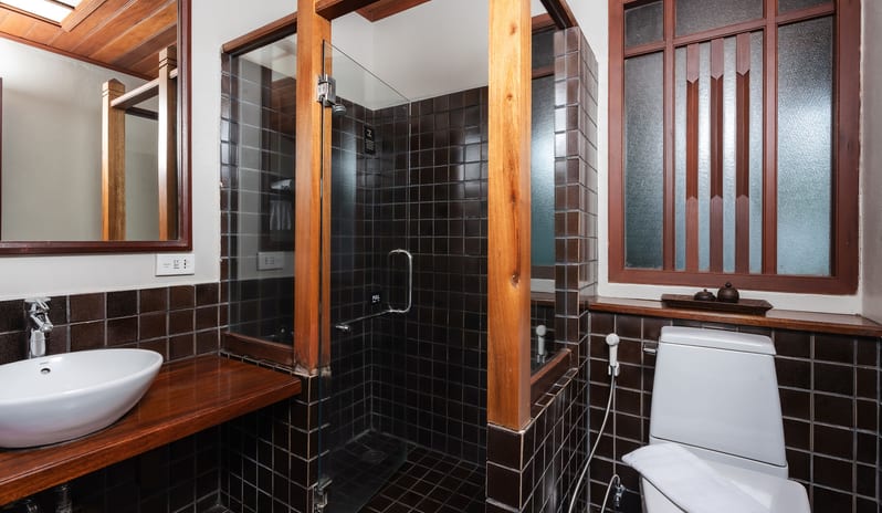 Oriental Villa bathroom with glass shower cubicle and wood accents at Khaolak Laguna Resort by Kenwood Travel