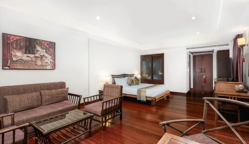 Siam Chaletat bedroom with wooden furniture and sofa lounge at Khaolak Laguna Resort by Kenwood Travel