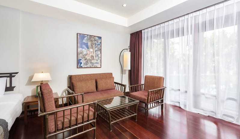 Siam Chaletat bedroom with wooden furniture and sofa lounge at Khaolak Laguna Resort by Kenwood Travel
