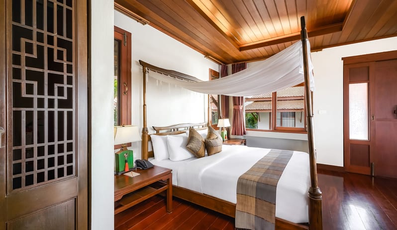 Similan Pearl four-poster canopy bed, polished wood floors, and traditional wooden ceiling panels at Khaolak Laguna Resort by Kenwood Travel