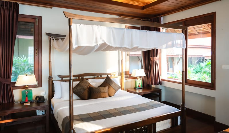 Similan Pearl bedroom with a traditional wooden canopy bed at Khaolak Laguna Resort by Kenwood Travel