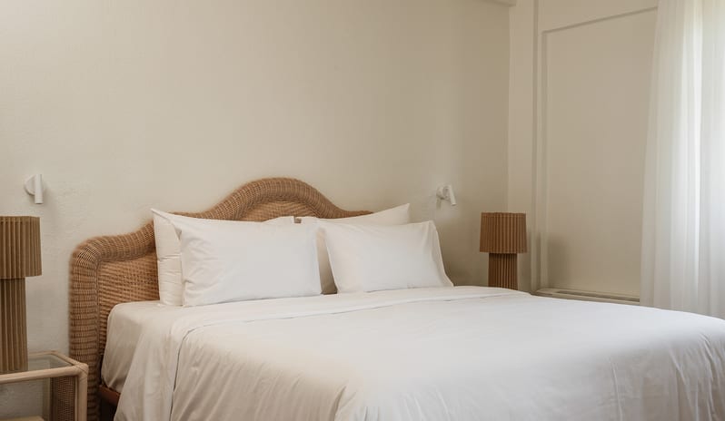 Family Interconnecting Loft Private Balcony white cotton bed sheets and fluffy pillows neatly styled on a bed in a sunlit room at Grecotel LUXME Costa Botanica by Kenwood Travel