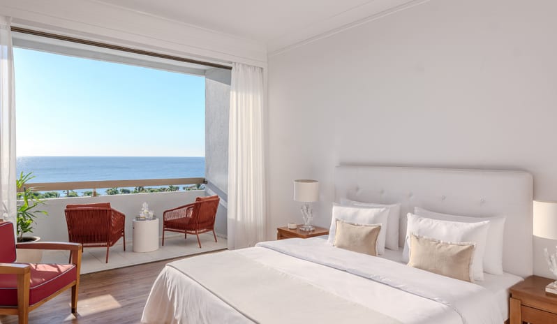LUX ME Sea View Guestroom Modern luxury beach resort guestroom with floor-to-ceiling windows overlooking the Mediterranean Sea in Rhodes at Grecotel LUXME Dama Dama by Kenwood Travel